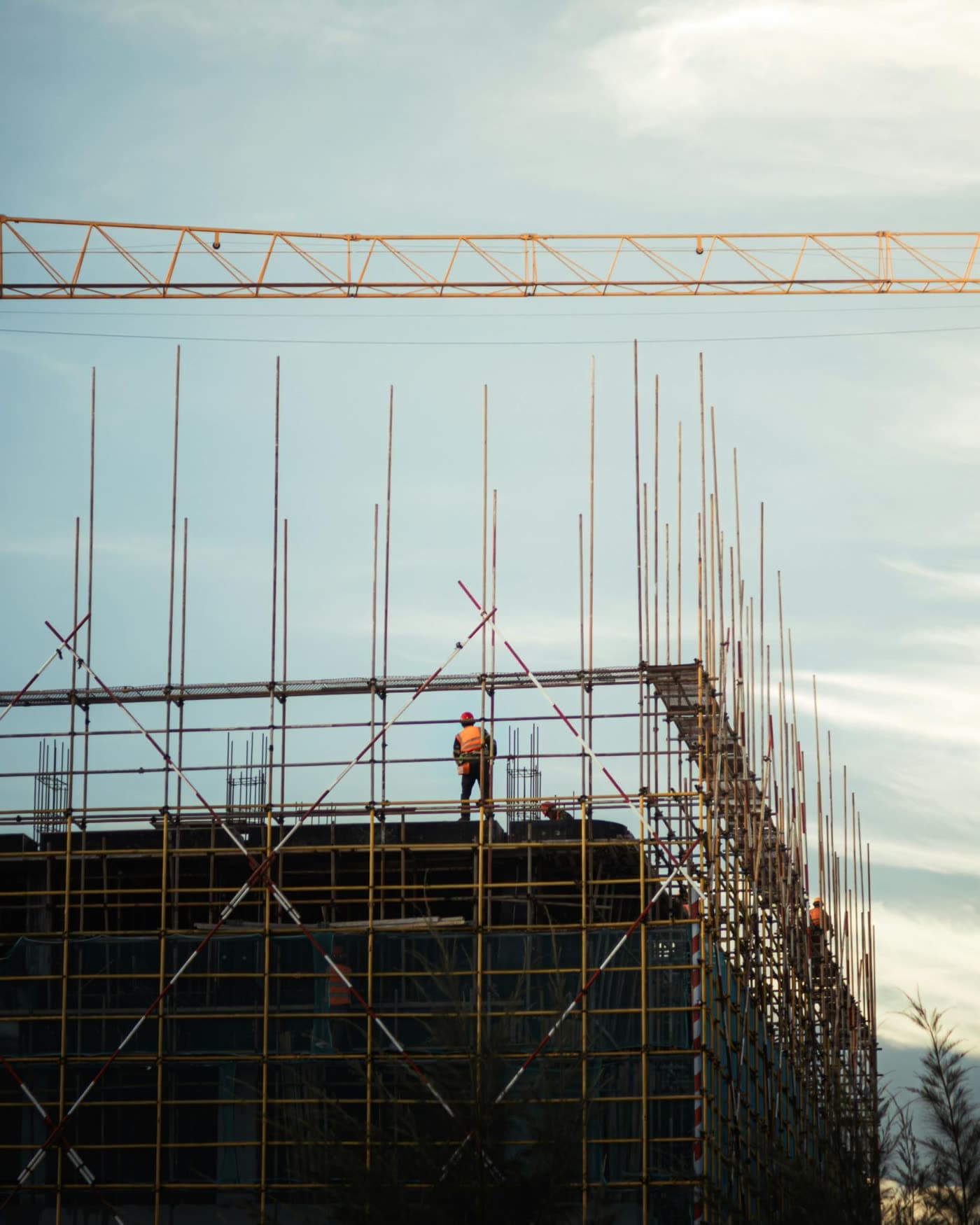 Ouvrier sur échafaudages, grue en arrière-plan